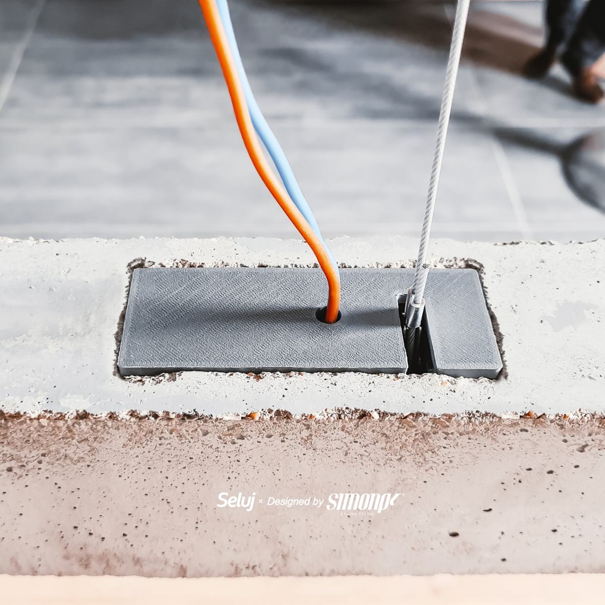 Détail du câble de suspension et de la pièce imprimée en 3D dans le béton